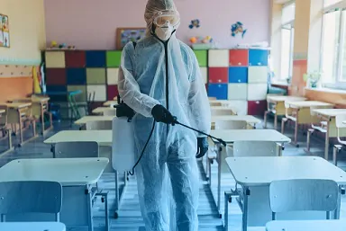 pracownik czyści ławki w szkole